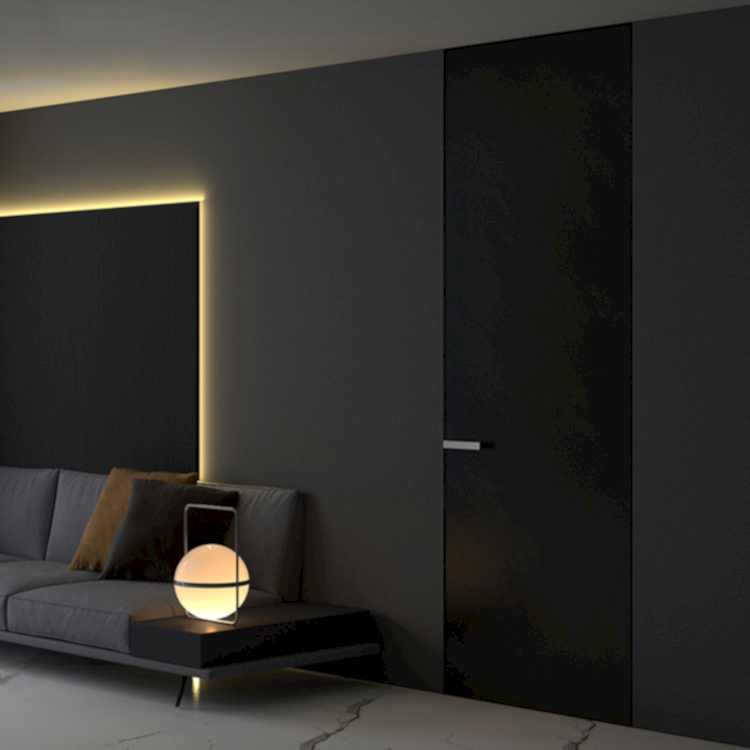 Modern black invisible interior door with a seamless flush design, featuring a sleek handle and integrated into a minimalist dark-toned living space.